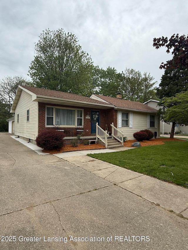 6187 Towar Ave, East Lansing, MI 48823 - ranch-style house featuring brick siding, a front yard, and a chimney
