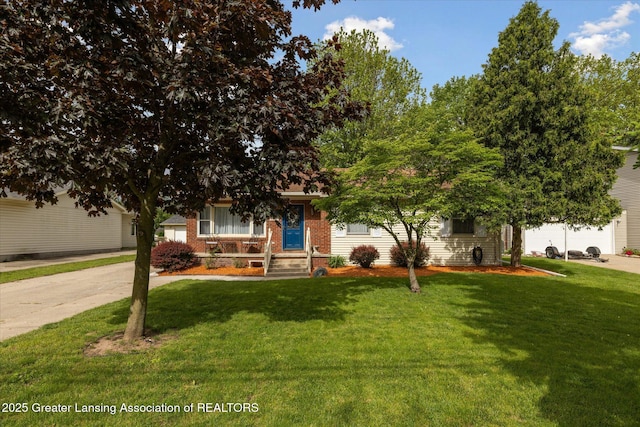 6187 Towar Ave, East Lansing, MI 48823 - view of property hidden behind natural elements with a front lawn, brick siding, a garage, and driveway