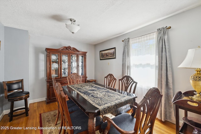 6187 Towar Ave, East Lansing, MI 48823 - dining area with light wood-type flooring, a textured ceiling, and baseboards