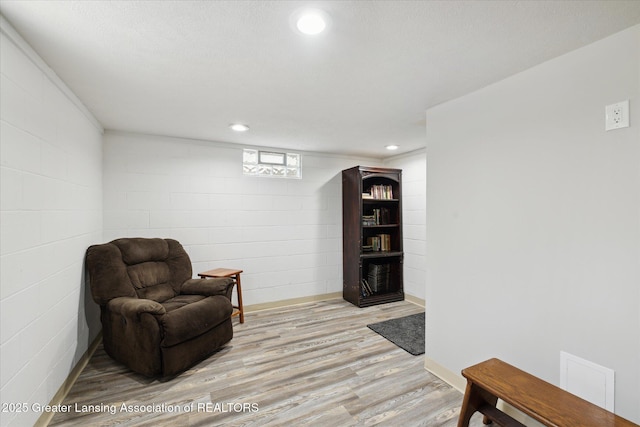 6187 Towar Ave, East Lansing, MI 48823 - sitting room with light wood finished floors, concrete block wall, and recessed lighting