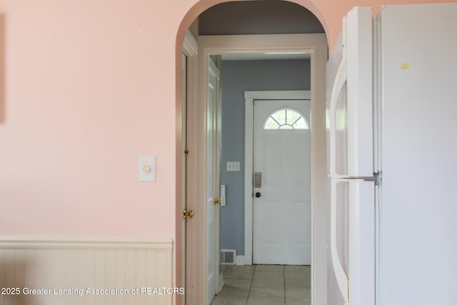 1311 Moores River Dr, Lansing, MI 48910 - hallway with arched walkways, light tile patterned flooring, and wainscoting