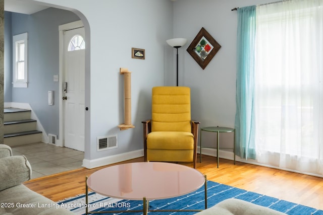 1311 Moores River Dr, Lansing, MI 48910 - living area featuring arched walkways, wood finished floors, stairs, and baseboards