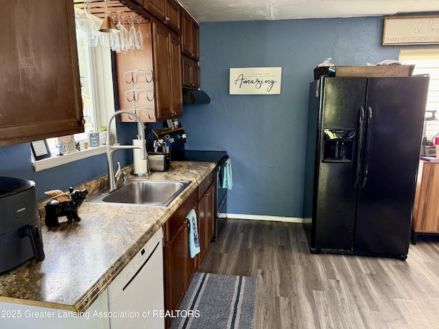 5880 Shaw St, Haslett, MI 48840 - kitchen with black fridge with ice dispenser, electric stove, white dishwasher, wood finished floors, and plenty of natural light