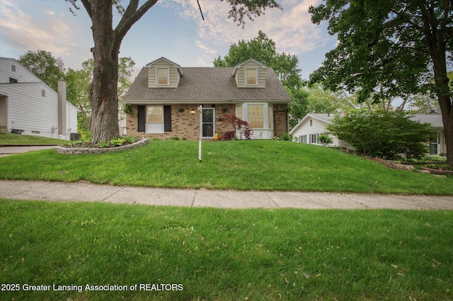 2024 Cogswell Dr, Lansing, MI 48906 - cape cod home with brick siding, a front yard, and roof with shingles