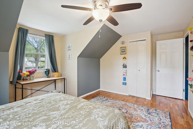 2024 Cogswell Dr, Lansing, MI 48906 - bedroom featuring wood finished floors, vaulted ceiling, a closet, baseboards, and a ceiling fan