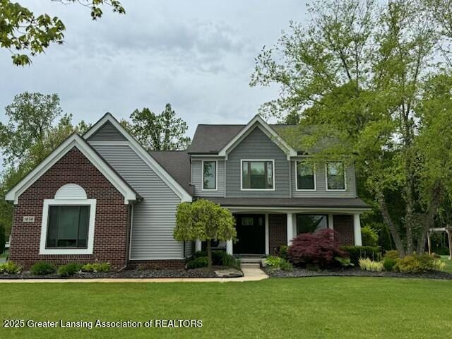 1232 Chemung Forest Dr, Howell, MI 48843 - craftsman-style home with brick siding, a front yard, and a porch