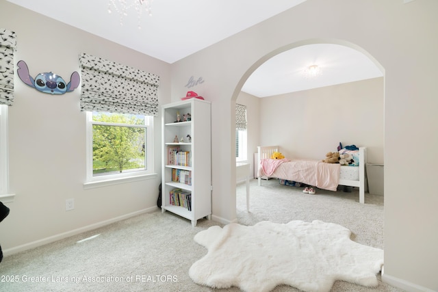 1232 Chemung Forest Dr, Howell, MI 48843 - bedroom with arched walkways, carpet flooring, baseboards, and a chandelier