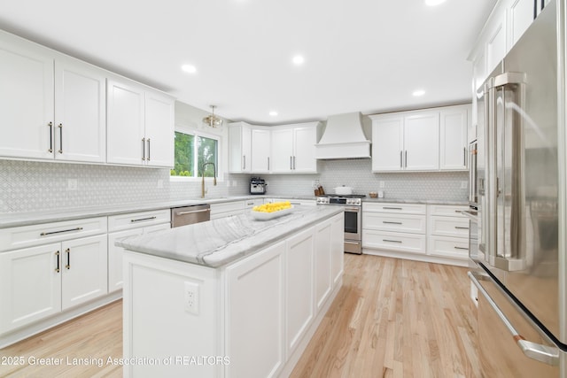 1232 Chemung Forest Dr, Howell, MI 48843 - kitchen with stainless steel appliances, custom range hood, backsplash, a kitchen island, and recessed lighting