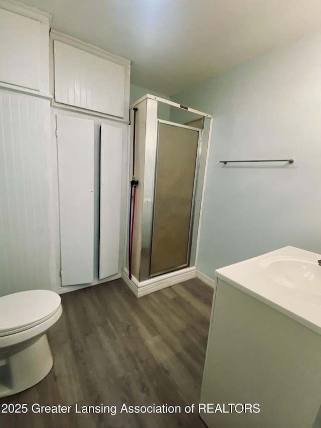 3319 Westmont Ave, Lansing, MI 48906 - full bathroom featuring wood finished floors, a shower stall, vanity, and toilet