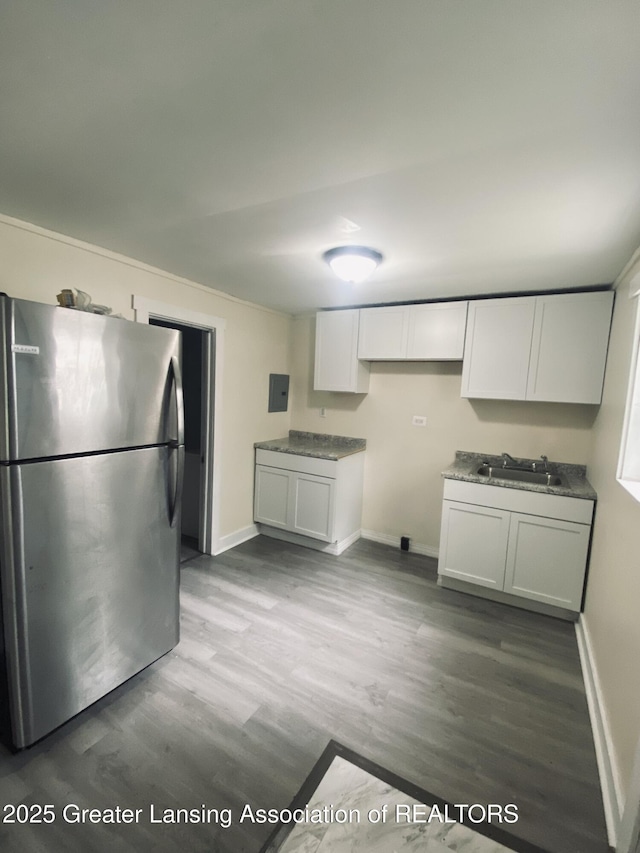 3319 Westmont Ave, Lansing, MI 48906 - kitchen with freestanding refrigerator, a sink, wood finished floors, and baseboards