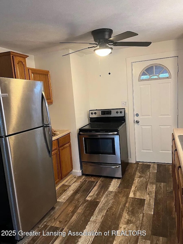 3319 Westmont Ave, Lansing, MI 48906 - kitchen featuring stainless steel appliances, brown cabinets, dark wood-style flooring, a ceiling fan, and light countertops