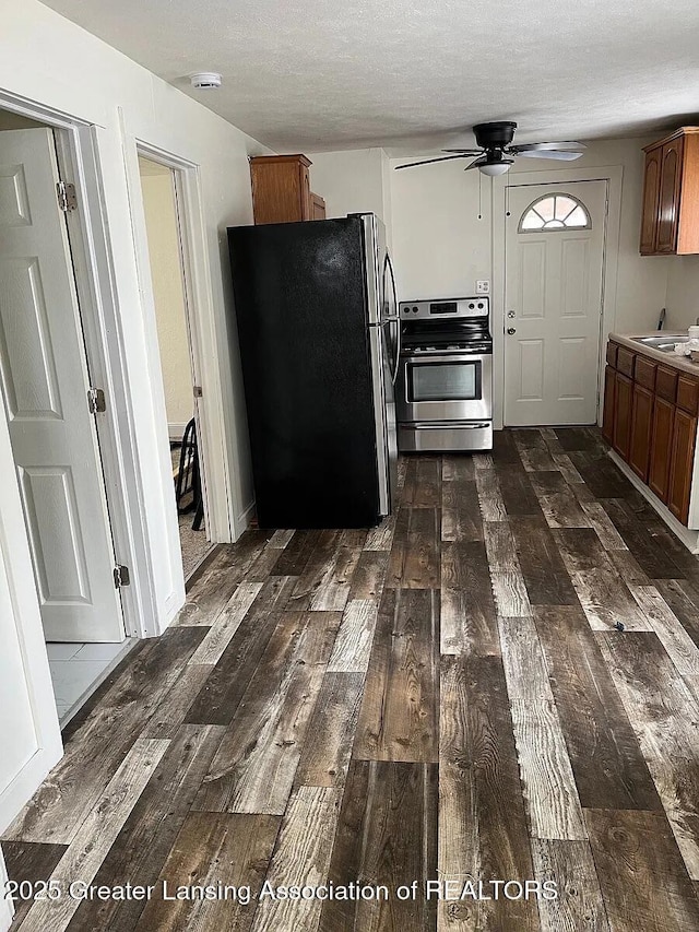 3319 Westmont Ave, Lansing, MI 48906 - kitchen featuring stainless steel appliances, dark wood-type flooring, ceiling fan, brown cabinets, and a textured ceiling