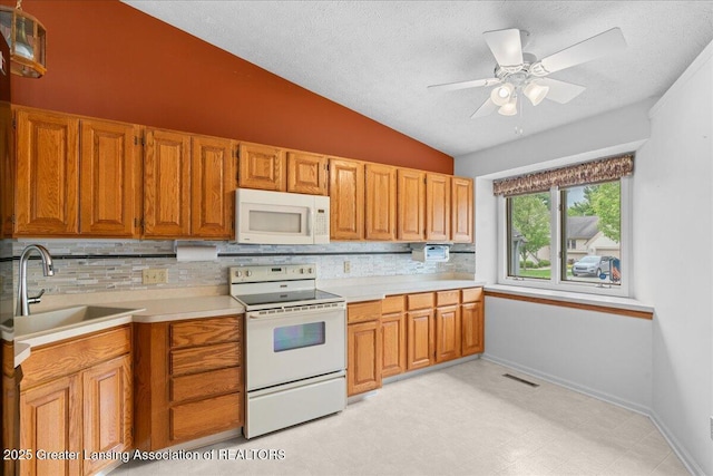 1101 Boulder Ct Unit 48, Lansing, MI 48917 - kitchen featuring white appliances, lofted ceiling, a sink, backsplash, and a textured ceiling