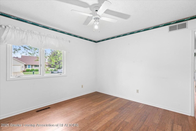 1101 Boulder Ct Unit 48, Lansing, MI 48917 - unfurnished room with wood finished floors, a ceiling fan, baseboards, and a textured ceiling