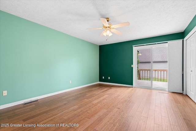 1101 Boulder Ct Unit 48, Lansing, MI 48917 - empty room featuring a ceiling fan, wood finished floors, a textured ceiling, and baseboards