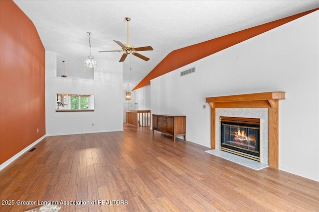 1101 Boulder Ct Unit 48, Lansing, MI 48917 - unfurnished living room featuring ceiling fan, wood finished floors, a fireplace with flush hearth, high vaulted ceiling, and baseboards