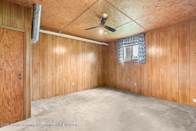 1101 Boulder Ct Unit 48, Lansing, MI 48917 - empty room featuring carpet flooring, a ceiling fan, and wood walls