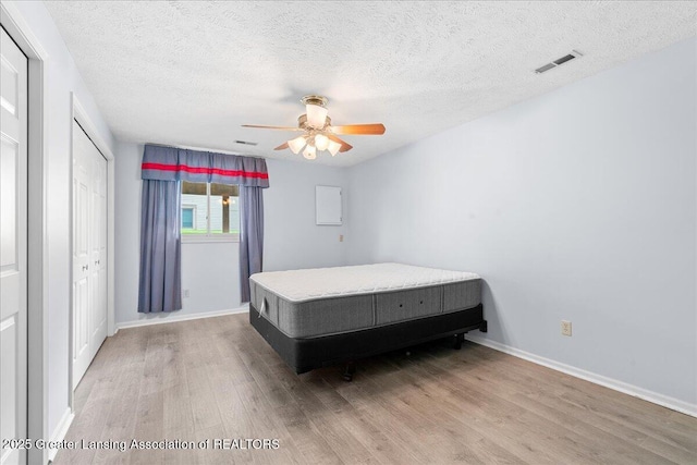 1101 Boulder Ct Unit 48, Lansing, MI 48917 - bedroom with wood finished floors, baseboards, a textured ceiling, and ceiling fan