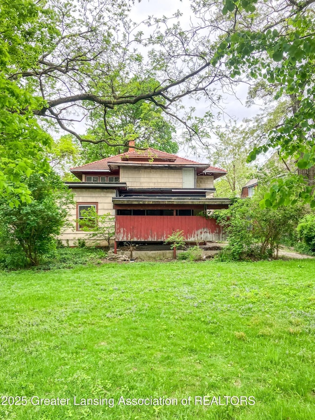 908 N Capitol Ave, Lansing, MI 48906 - rear view of property featuring a yard and a chimney