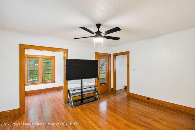2104 Clifton Ave, Lansing, MI 48910 - unfurnished living room with baseboards, wood finished floors, and a ceiling fan