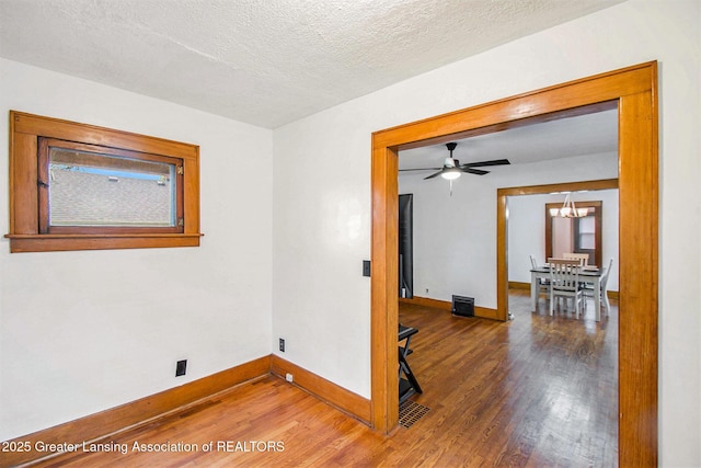 2104 Clifton Ave, Lansing, MI 48910 - unfurnished room featuring wood finished floors, baseboards, a chandelier, and a textured ceiling