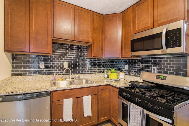 2104 Clifton Ave, Lansing, MI 48910 - kitchen featuring stainless steel appliances, a sink, backsplash, and light stone countertops