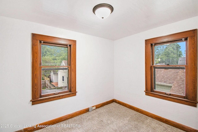 2104 Clifton Ave, Lansing, MI 48910 - spare room featuring healthy amount of natural light, carpet, and baseboards