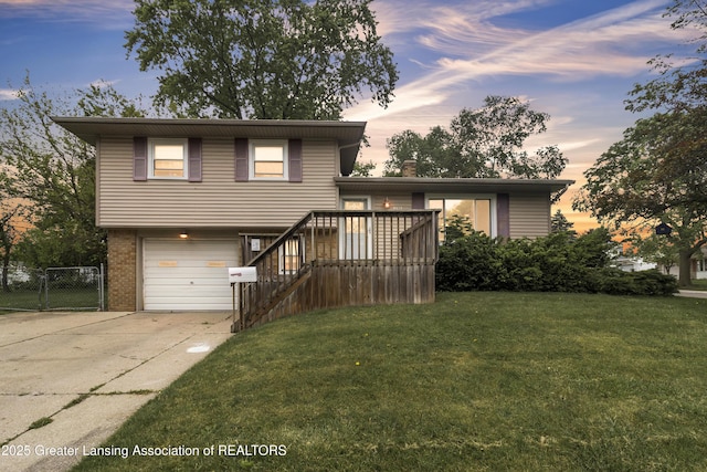 1021 Kendon Dr, Lansing, MI 48910 - tri-level home with driveway, a garage, brick siding, a gate, and stairs