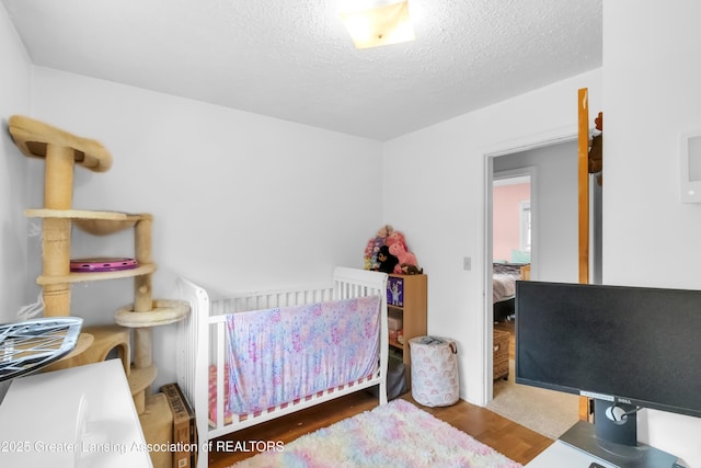 1021 Kendon Dr, Lansing, MI 48910 - bedroom with wood finished floors and a textured ceiling