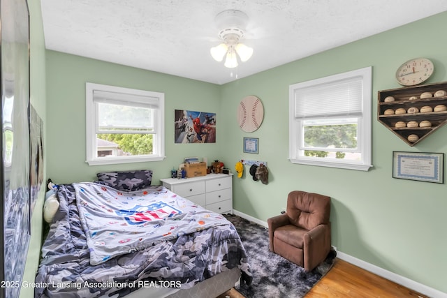 1021 Kendon Dr, Lansing, MI 48910 - bedroom with multiple windows, baseboards, and wood finished floors