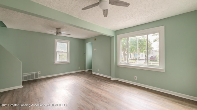 621 Ridgewood Ave, Lansing, MI 48910 - unfurnished room featuring a ceiling fan, a textured ceiling, healthy amount of natural light, wood finished floors, and baseboards