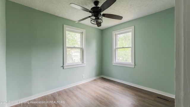 621 Ridgewood Ave, Lansing, MI 48910 - empty room with healthy amount of natural light, a textured ceiling, wood finished floors, baseboards, and ceiling fan