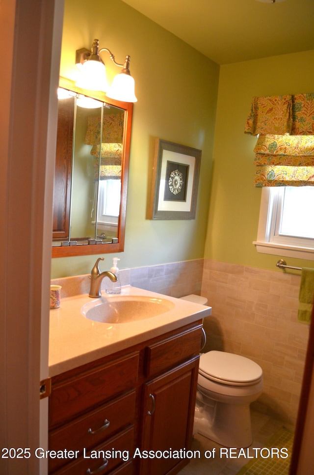 1161 Rebecca Rd, East Lansing, MI 48823 - bathroom featuring tile walls, toilet, vanity, and a wainscoted wall