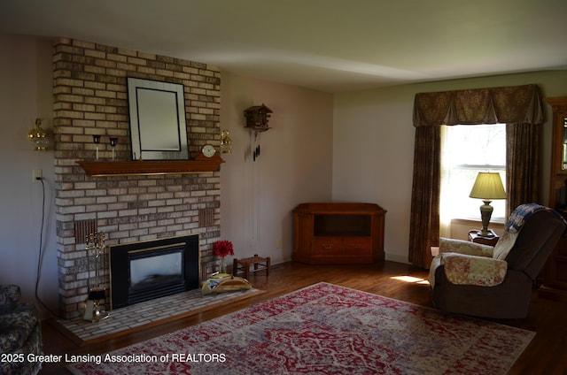 1161 Rebecca Rd, East Lansing, MI 48823 - living area featuring a brick fireplace, wood finished floors, and baseboards