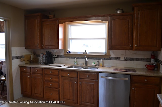 1161 Rebecca Rd, East Lansing, MI 48823 - kitchen featuring dishwasher, a sink, brown cabinetry, light countertops, and tasteful backsplash