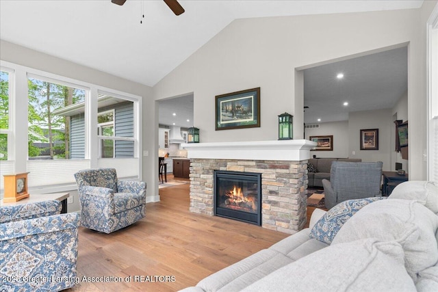 6619 Windford Ln, Grand Ledge, MI 48837 - living area featuring a ceiling fan, wood finished floors, a fireplace, high vaulted ceiling, and baseboards