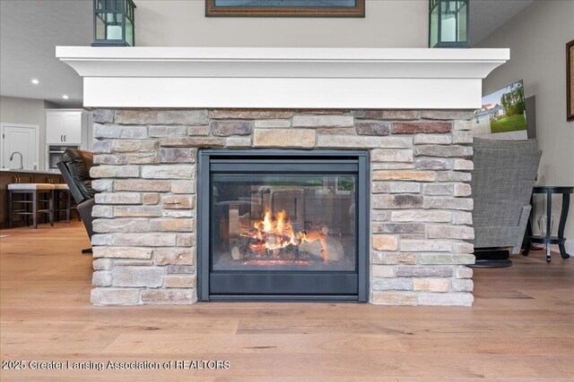 6619 Windford Ln, Grand Ledge, MI 48837 - detailed view of wood finished floors, a glass covered fireplace, and recessed lighting