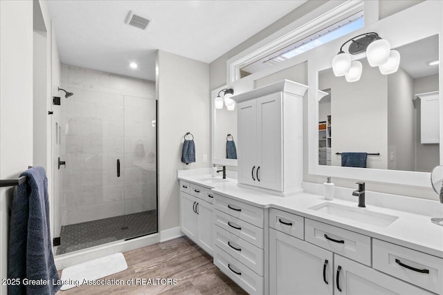 6619 Windford Ln, Grand Ledge, MI 48837 - full bathroom with a shower stall, double vanity, wood finished floors, baseboards, and recessed lighting