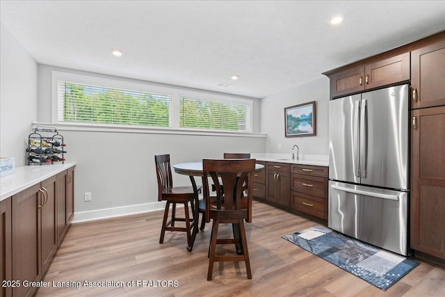 6619 Windford Ln, Grand Ledge, MI 48837 - kitchen featuring freestanding refrigerator, light wood finished floors, healthy amount of natural light, a sink, and recessed lighting
