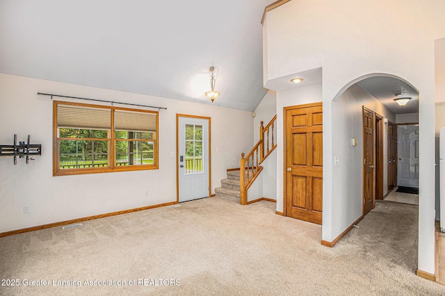 3037 Hawley Rd, Leslie, MI 49251 - carpeted entryway featuring baseboards, arched walkways, stairway, and lofted ceiling