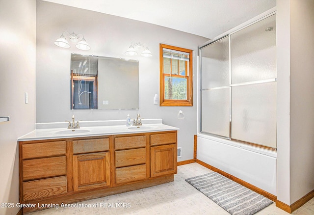 3037 Hawley Rd, Leslie, MI 49251 - full bathroom with double vanity, combined bath / shower with glass door, and baseboards