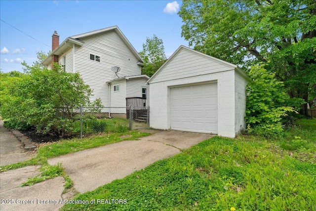329 Smith Ave, Lansing, MI 48910 - view of side of property with driveway, an outbuilding, a garage, and a chimney