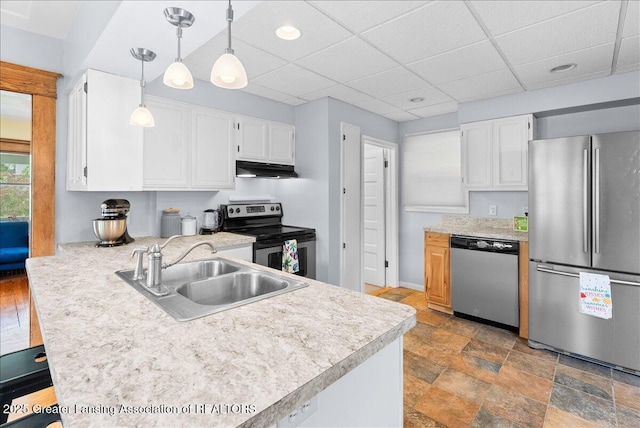 329 Smith Ave, Lansing, MI 48910 - kitchen featuring stainless steel appliances, a sink, a peninsula, light countertops, and a paneled ceiling