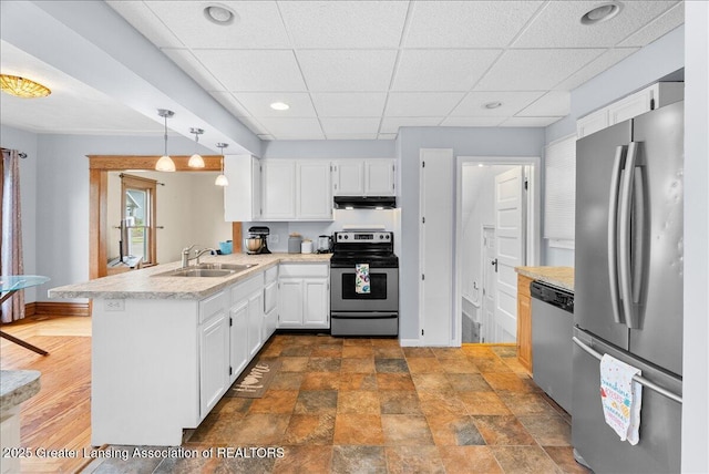 329 Smith Ave, Lansing, MI 48910 - kitchen with stainless steel appliances, a sink, under cabinet range hood, a peninsula, and a drop ceiling