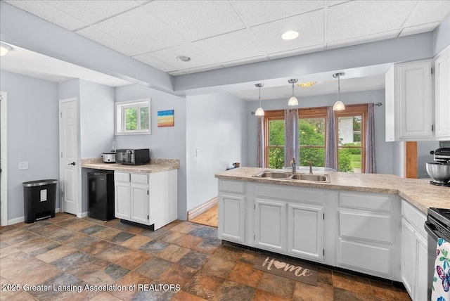 329 Smith Ave, Lansing, MI 48910 - kitchen featuring a sink, white cabinets, a peninsula, refrigerator, and a paneled ceiling