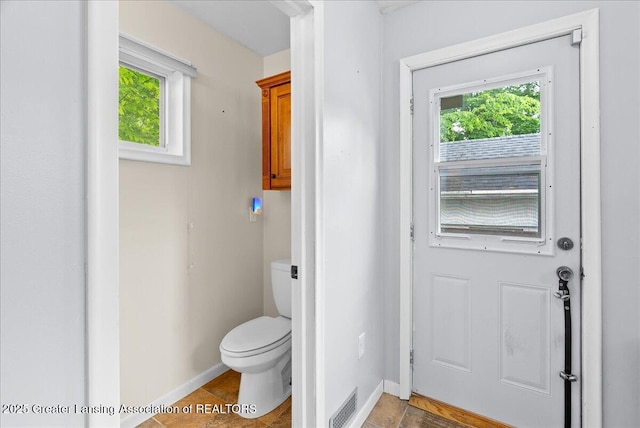 329 Smith Ave, Lansing, MI 48910 - bathroom featuring healthy amount of natural light, toilet, and baseboards