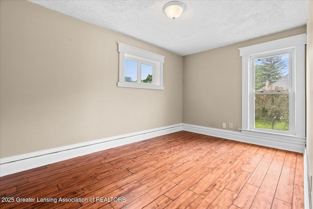 329 Smith Ave, Lansing, MI 48910 - empty room with wood finished floors, a textured ceiling, and baseboards