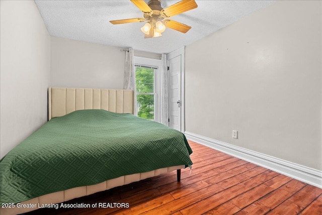 329 Smith Ave, Lansing, MI 48910 - bedroom featuring wood finished floors, baseboards, a textured ceiling, and ceiling fan