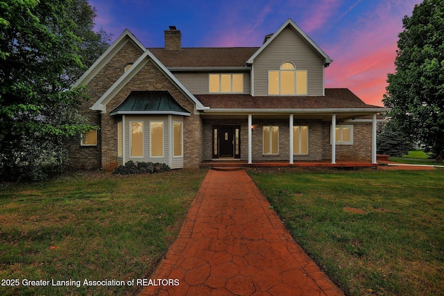 4250 S Williams Rd, Stockbridge, MI 49285 - view of front facade featuring a chimney, a front yard, brick siding, and a shingled roof