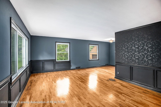 710 Gainsborough Dr, East Lansing, MI 48823 - spare room featuring a decorative wall, wood finished floors, and a wainscoted wall